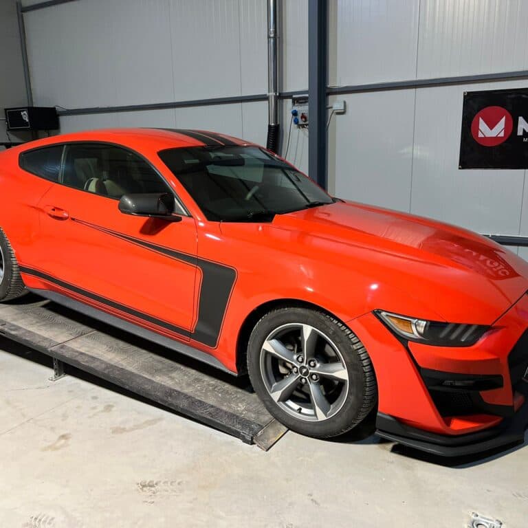 Ford Mustang roșu poziționat pe standul dyno cu rulouri din atelierul RemPerformance